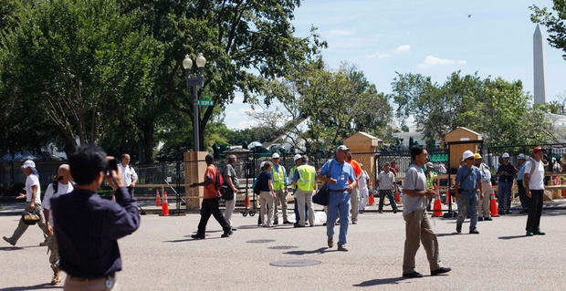 Office and construction workers at the White House complex cross Pennsylvania Ave. in Washington, Aug. 23, 2011, after buildings where evacuated following an earthquake in the Washington area.  