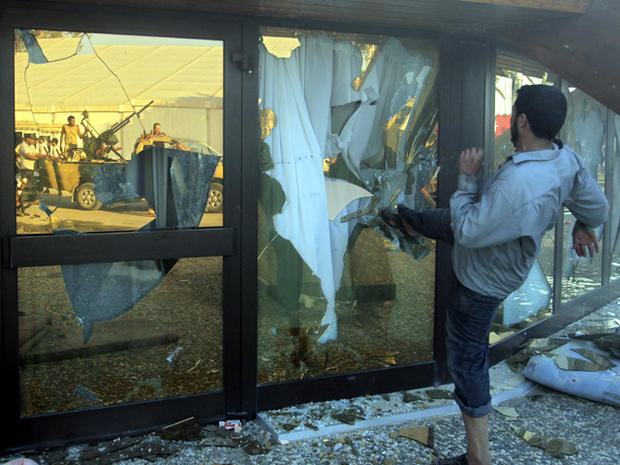 A rebel fighter brakes the glass of Muammar Qaddafi's tent inside his main compound in Bab Al-Aziziya in Tripoli, Libya, Aug. 23, 2011. Libyan rebels stormed Qaddafi's main military compound in Tripoli after fierce fighting with forces loyal to his regime 