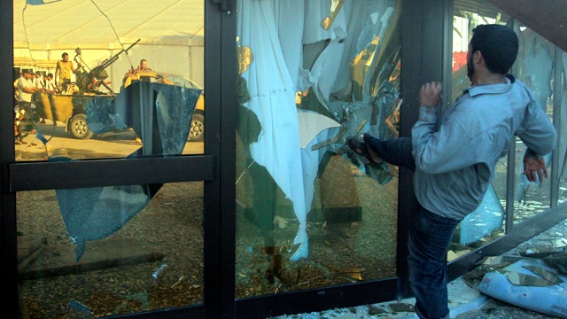 A rebel fighter brakes the glass of Muammar Qaddafi's tent inside his main compound in Bab Al-Aziziya in Tripoli, Libya, Aug. 23, 2011. Libyan rebels stormed Qaddafi's main military compound in Tripoli after fierce fighting with forces loyal to his regime 