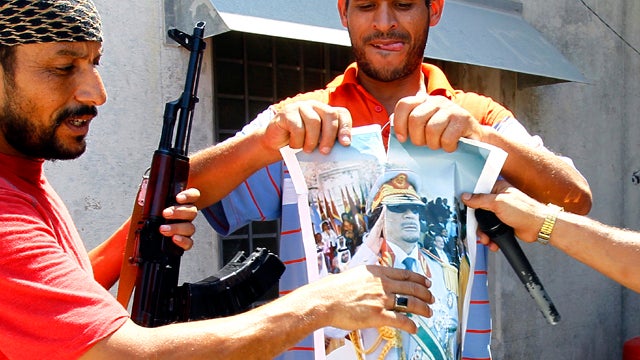 Rebel fighters tear up a portrait of Muammar Qaddafi inside his compound Bab al-Aziziya in Tripoli, Libya, Aug. 24, 2011. Hundreds of Libyan rebels stormed Qaddafi's compound a day earlier, charging wildly through the symbolic heart of the crumbling regim 