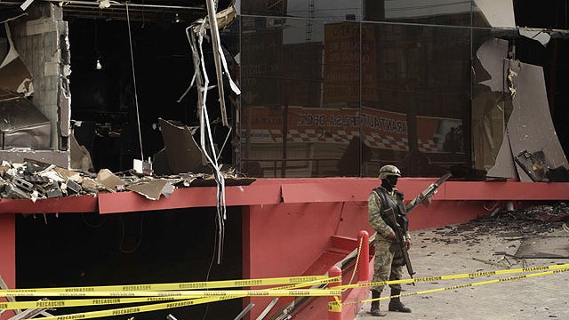 A soldier stands guard outside the Casino Royale after a deadly assault that killed at least 52 people in Monterrey, Mexico, Aug, 26, 2011.   