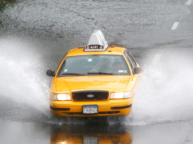 taxi cab drives through a flooded lane of FDR Drive  