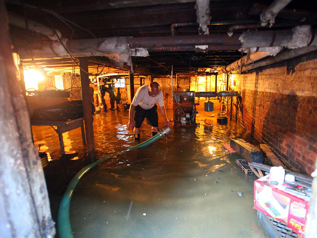 Nick Feola tries to get the gallons of water out of his basement at his home of 32 years on 5th Street in Hoboken, N.J.  
