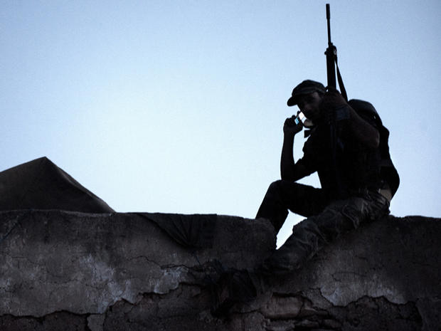 A Libyan rebel gets a signal on his mobile phone on the roof of the last checkpoint in Gualish, Libya, July 25, 2011. 
