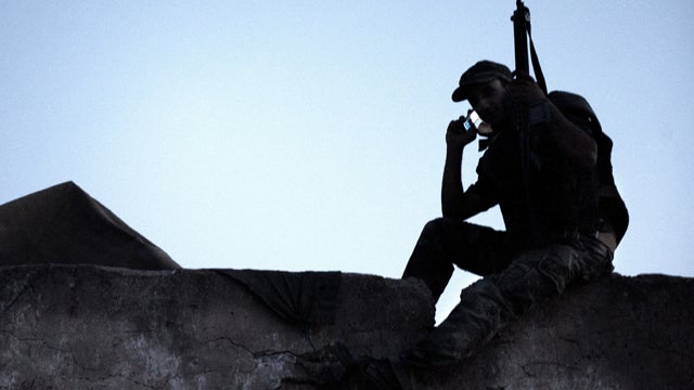 A Libyan rebel gets a signal on his mobile phone on the roof of the last checkpoint in Gualish, Libya, July 25, 2011. 