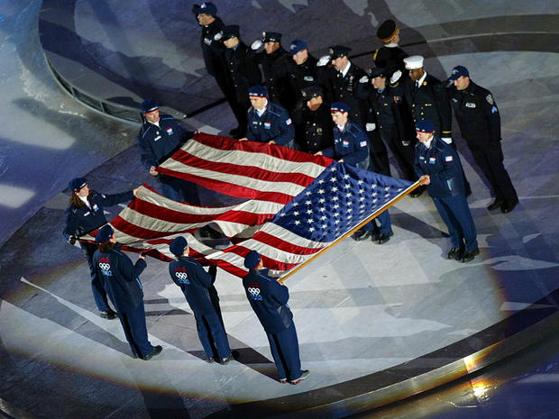 Members of the New York police and fire departments salute as U.S. athletes hold the flag found at Ground Zero at the Opening Ceremony of the 2002 Salt Lake City Winter Olympic Games at the Rice-Eccles Olympic Stadium Feb. 8, 2002, in Salt Lake City. 