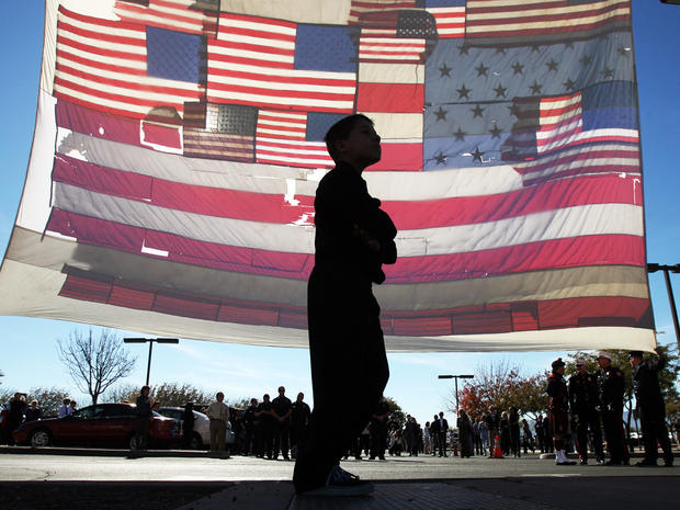 A boy walks past the National 9/11 Flag, recovered after the Sept. 11, 2001, terrorist attacks in New York City, outside the entrance of the St. Elizabeth Ann Seton Church for the funeral of 9-year-old Christina Taylor Green Jan. 13, 2011, in Tucson, Ariz 