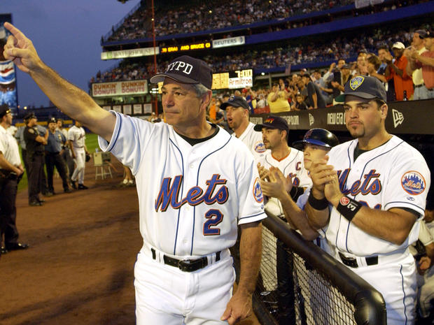 New York Mets manager Bobby Valentine, wearing a New York Police Department cap, and catcher Mike Piazza, wearing a Port Authority Police Department cap, applaud in honor of New York City Mayor Rudy Giuliani before a baseball game against the Atlanta Braves Sept. 21, 2001, at Shea Stadium in Flushing, N.Y. The Mets won 3-2. 