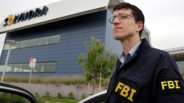 An FBI agent stands guard outside of Solyndra headquarters in Fremont, Calif., Sept. 8, 2011, while the bureau was executing search warrants at the headquarters of the solar firm that received a $535 million loan from the federal government. 