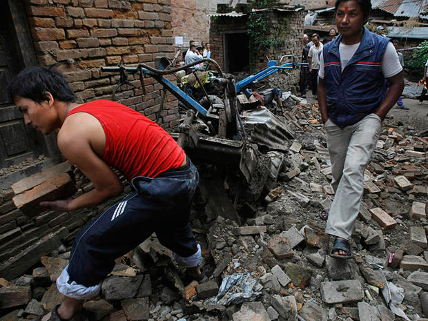 Nepalese man removes debris of collapsed buildings 