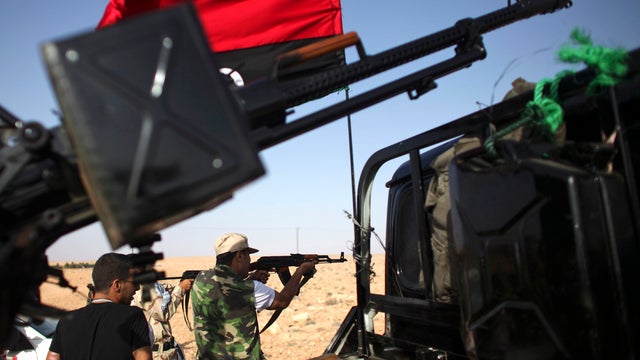 Revolutionary fighters practice shooting at a checkpoint in Wadi Dinar, Libya, Sept. 20, 2011. A push to capture Muammar Qaddafi's hometown of Sirte and the mountain enclave of Bani Walid has stalled as well-armed forces loyal to the fugitive leader fight 