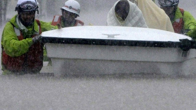 Rescue workers transport evacuees in a boat through floodwaters in Nagoya, Japan, Sept. 20, 2011. Hundreds of thousands of people in Japan were warned to leave their homes as an approaching typhoon brought heavy rain and fears of landslides and flash floo 