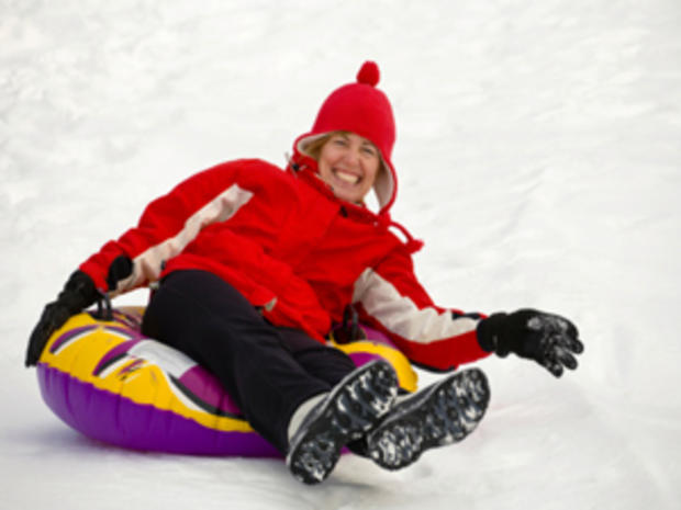 12/23/11 - A Guide to Snow Tubing in the Twin Cities Area- woman in red jacket on purple/yellow tube  