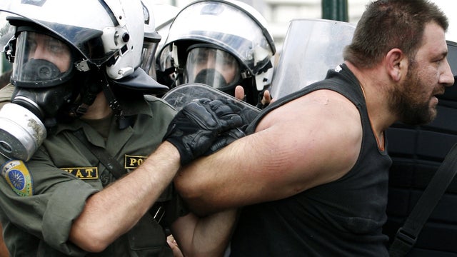 Riot police officers detain a protester during minor clashes in Athens Oct. 5, 2011. At least 16,000 protesters converged in the Greek capital, and a crowd of about 10,000 gathered in the northern city of Thessaloniki as Greek civil servants walked off th 