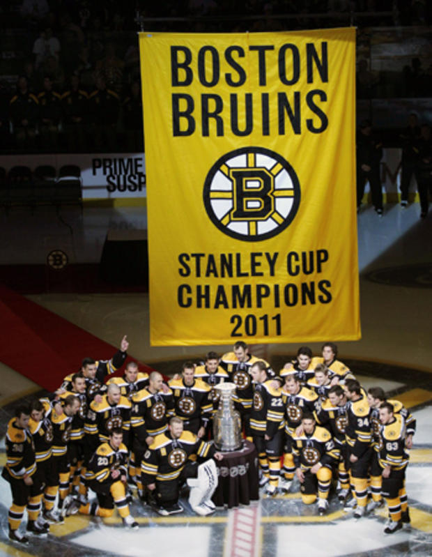 Boston Bruins pose with the Stanley Cup and championship banner 