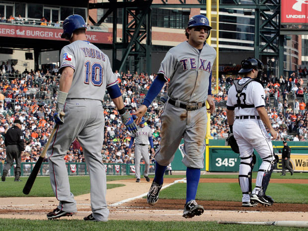 Ian Kinsler is congratulated by Michael Young after scoring 