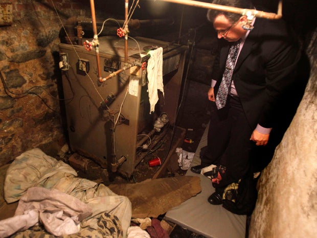 Philadelphia police Sgt. Joseph Green stands in the dank basement room in Philadelphia where four weak and malnourished mentally disabled adults, including one chained to the boiler, were found locked inside Oct. 17, 2011. Police arrested three adults staying in an apartment upstairs, including the person accused of being the ringleader, Linda Ann Weston, in what authorities say is a scheme to steal the Social Security disability checks of defenseless and vulnerable people.