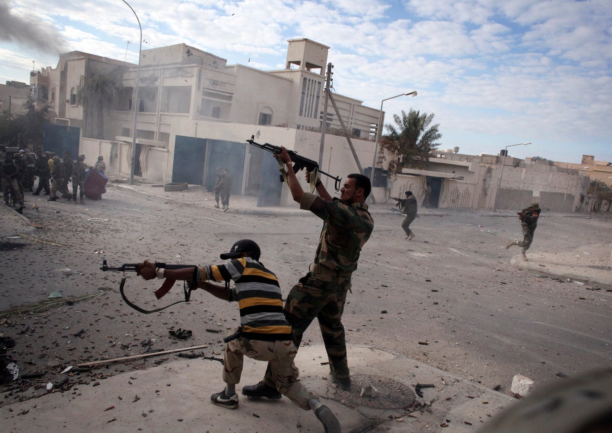 Libyan rebel fighters fire their machine guns  