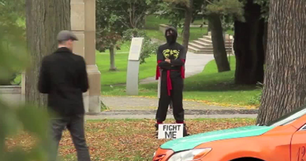 Ninja standing in front of sign that says 