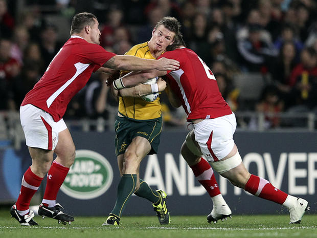Huw Bennett and Dan Lydiate tackle Rob Horne 