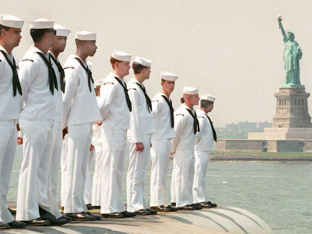 Sailors on the aircraft carrier USS America "man the rails" as the ship steams past the Statue of Liberty at the start of the eighth annual Fleet Week in New York May 24, 1995. The flagship was later berthed on Manhattan's West Side along with five other  