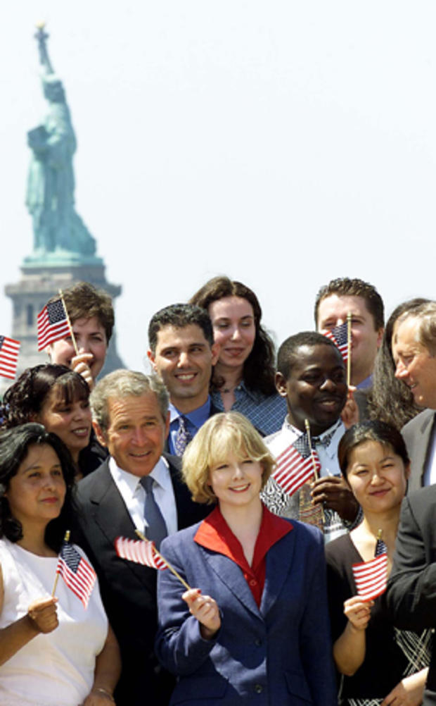 President George W. Bush and New York Gov. George Pataki, far right, pose in front of the Statue of Liberty with new U.S. citizens on Ellis Island in New York City July 10, 2001, just after a swearing-in ceremony for the new citizens. 