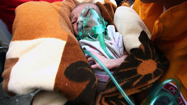 A Turkish medical doctor carries Azra Karaduman, a two-week-old baby girl saved by Turkish rescuers who continue to work to save people trapped under debris of a collapsed building in Ercis, Van, eastern Turkey, Tuesday, Oct. 25, 2011.  