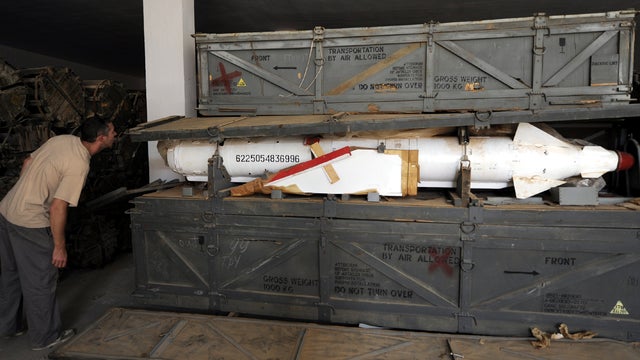 A Libyan man looks at a missile in a wooden crate in an ammunition storage bunker south of Sirte Oct. 26, 2011. 
