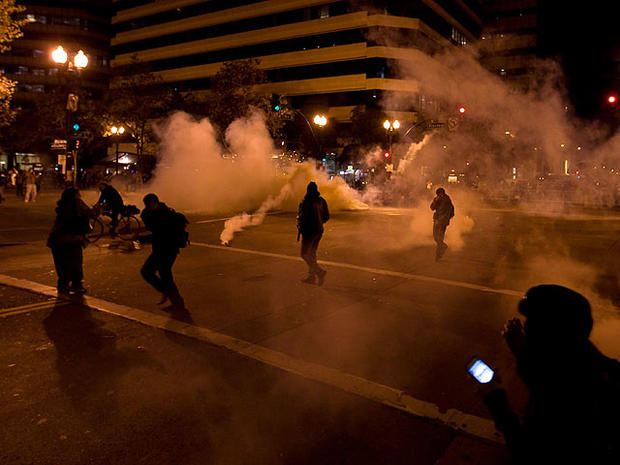 Occupy Wall Street protesters run from tear gas deployed by police at 14th Street and Broadway in Oakland, Calif., Oct. 25, 2011.  