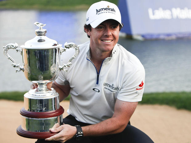 Rory McIlroy poses for photos with his trophy 