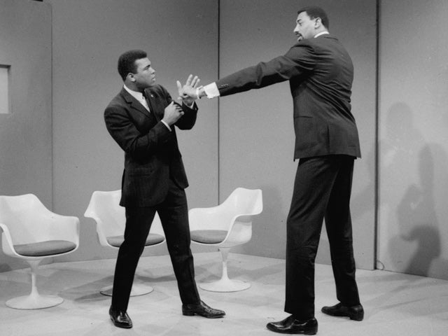 Wilt Chamberlain extends a long left in the direction of Muhammad Ali  