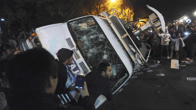 Penn State students flip a television news van during a riot 