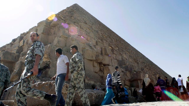 Egyptian soldiers walk at the base the pyramid of Khufu, the largest of the Giza Pyramids, in Cairo Nov. 11, 2011. Egypt's antiquities authority closed the pyramid following rumors that groups would try to hold spiritual ceremonies on the site at 11:11 a. 