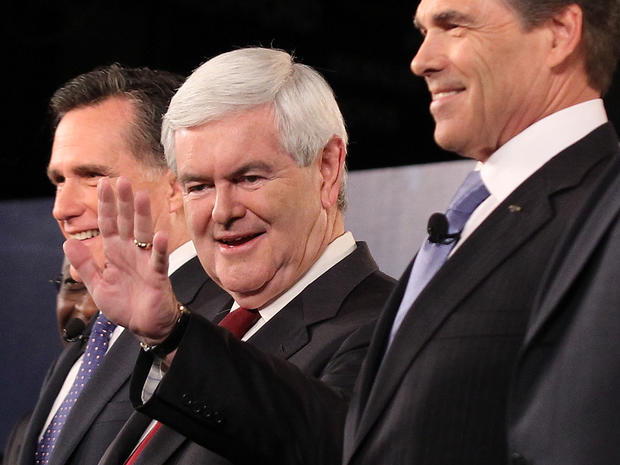 Republican presidential candidates (L-R) former Massachusetts Governor Mitt Romney, former Speaker of the House Newt Gingrich (R-GA), and Texas Governor Rick Perry acknowledge audience prior to a presidential debate at Wofford College November 12, 2011 in Spartanburg, South Carolina. The debate was focused on national security and foreign policy. 