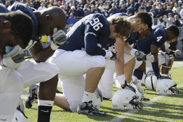 Penn State players kneel in prayer  