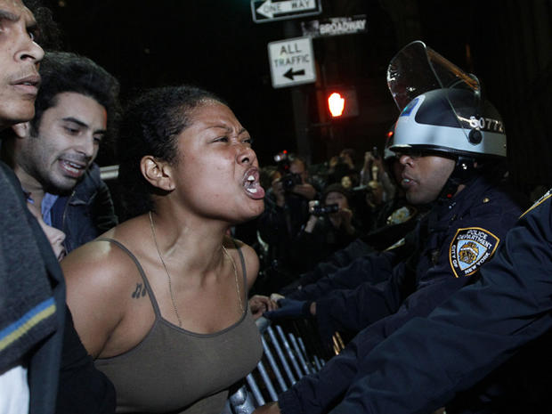 A demonstrator yells at police officers 