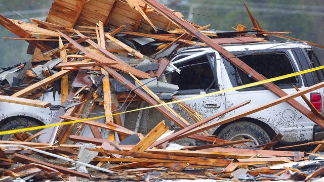 Debris covers a vehicle parked outside a business  