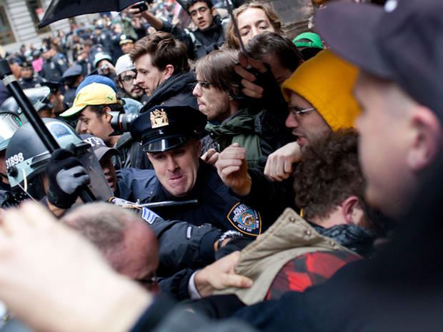 A police officer swings a baton into a crowd of people affiliated with the Occupy Wall Street movement at the intersection of Exchange Place and Beaver Street in New York's financial district Nov. 17, 2011. 