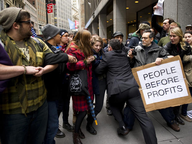 A businessman tries to break through a line of Occupy Wall Street protesters who had locked arms and blocked access to the New York Stock Exchange area Nov. 17, 2011, in New York. 