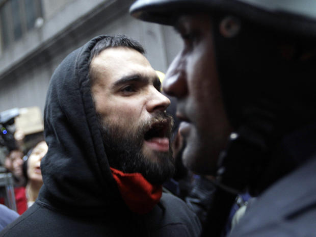 Demonstrators affiliated with the Occupy Wall Street movement confront a police officer as they march through the streets of New York's financial district Nov. 17, 2011. 