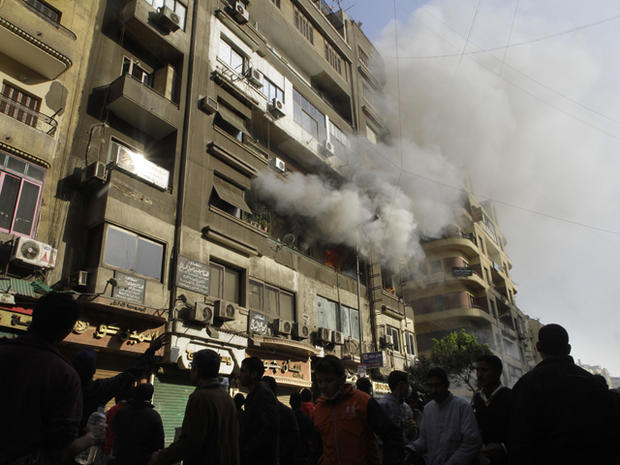 Egyptian protesters surround a fire set in a building near Tahrir Square 