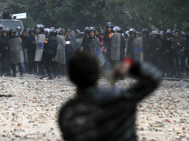 A protester throws stones at Egyptian riot police 