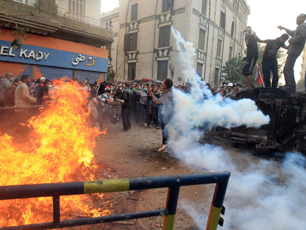 Egyptian protester forwards a tear gas canister  