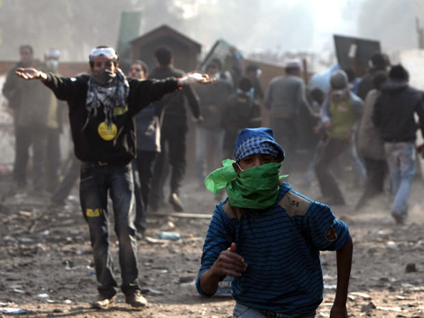 Egyptian protester run during clashes with riot police  