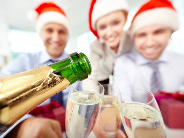 Close-up of bottle of champagne and flutes in the background of business people 