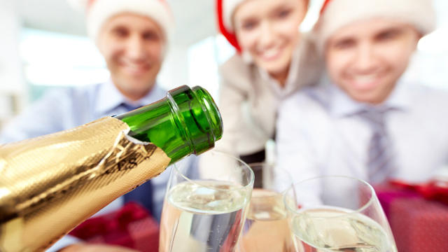 Close-up of bottle of champagne and flutes in the background of business people 