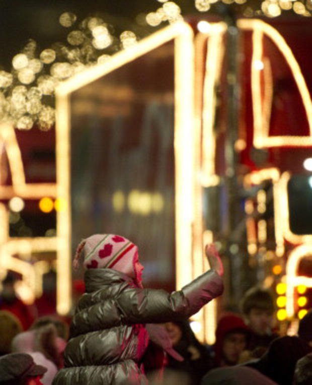 A young girl waves to Santa Claus on a f 