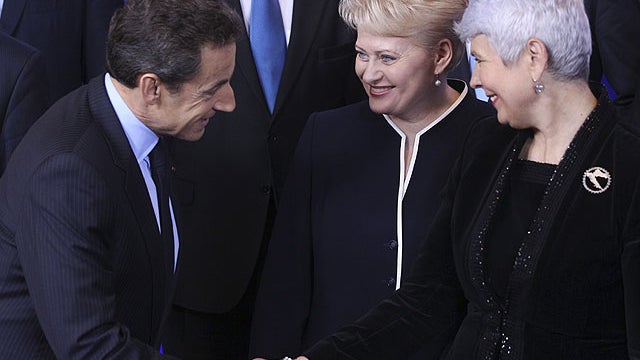 French President Nicolas Sarkozy, left, shakes hands with Croatian Prime Minister Jadranka Kosor, right, during a group photo at an EU summit in Brussels, Dec. 9, 2011.  