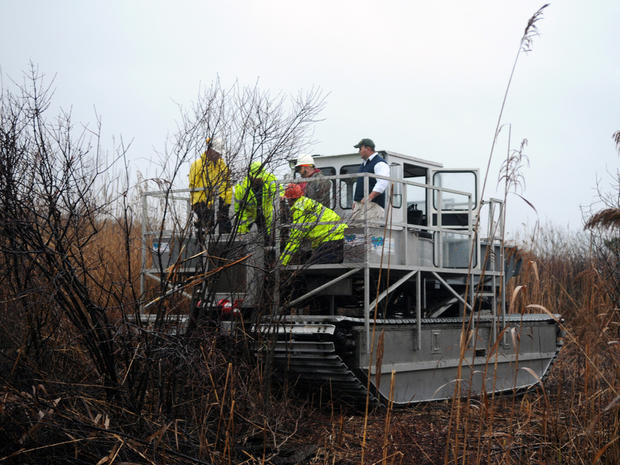 Suffolk County police use a ditcher to search through marsh on Dec. 7, 2011, in Oak Beach, N.Y. 