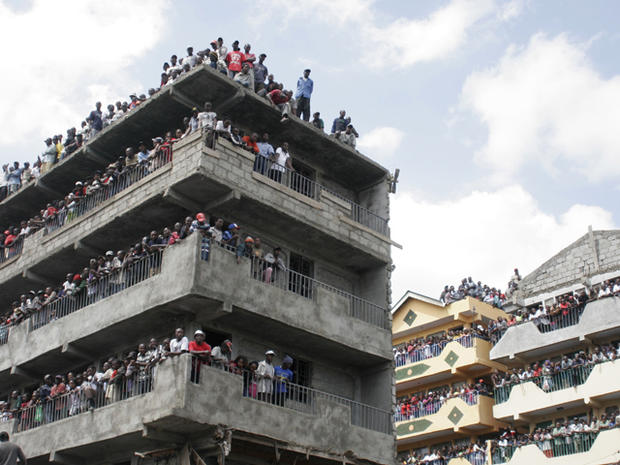 Crowds gather to watch a building after it collapsed 